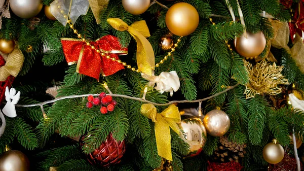 Closeup beautiful Christmas tree decorated with golden and red baubles and garlands. Winter holidays background or backdrop. — Stock Photo, Image