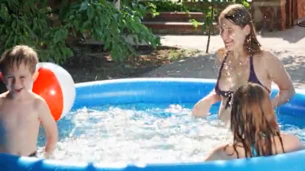 Zeitlupe fröhlich fröhliche Familie plantscht Wasser und hat Spaß am Freibad im Garten des Hauses Hinterhof. Konzept für fröhliche und fröhliche Sommerferien und Urlaub — Stockvideo