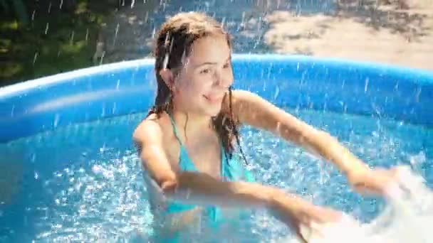 Powolny ruch szczęśliwy śmiech i wesoła dziewczyna pluskające wodą i o walkach wodnych w odkrytym basenie. Pojęcie szczęśliwej i wesołej rodziny letnie wakacje i wakacje — Wideo stockowe