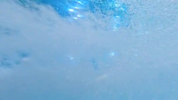 Underwater abstract shot of fast current and floating air bubbles in swimming pool. Beautiful background or backdrop — Stock Video