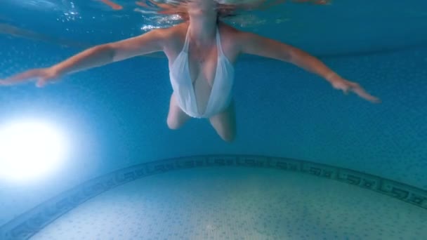 Vue sous-marine de la jeune femme enceinte qui attend bébé nageant et se relaxant dans la piscine. Concept de grossesse santé et sport. — Video