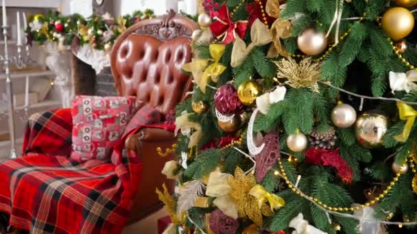 Hermoso interior de la sala de estar con sillón y brillante árbol de Navidad decoración para celebrar el Año Nuevo. Fondo o telón de fondo de vacaciones de invierno — Vídeo de stock