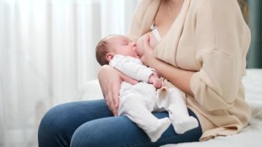 Anne ellerine uzanmış anne sütü emen tatlı bir erkek bebek. Sağlıklı ve doğal bebek emzirme kavramı.