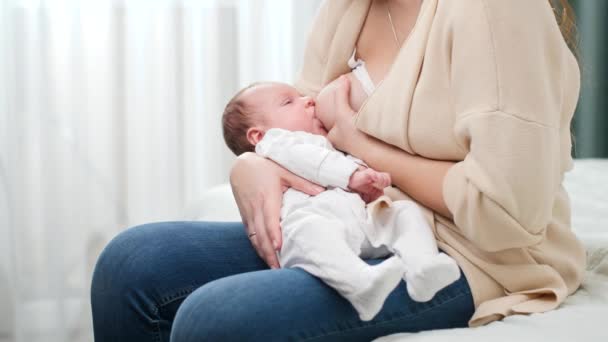 Lindo niño pequeño acostado en las manos de las madres y chupando la leche materna. Concepto de nutrición saludable y natural de la lactancia materna del bebé. — Vídeo de stock