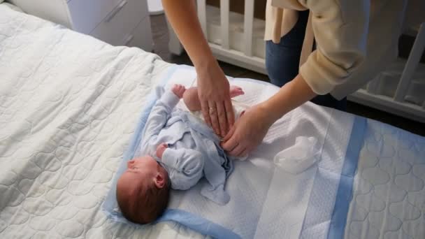 Vista dall'alto della giovane madre premurosa che cambia i pannolini disordinati del suo neonato di notte. Concetto di igiene, salute della madre e del bambino — Video Stock