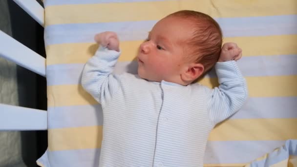 Vista superior de lindo bebé de 3 semanas de edad, acostado en la cama por la noche en habitación oscura. — Vídeo de stock