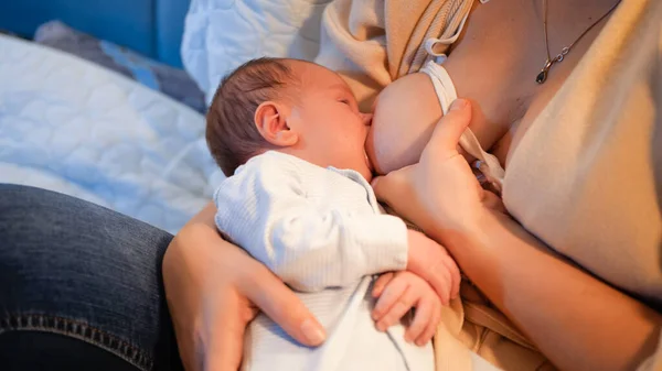 妈妈给她新生的小男孩喂奶.晚上在床上喂孩子的父母。健康和自然婴儿营养的概念。母亲和儿童的健康 — 图库照片