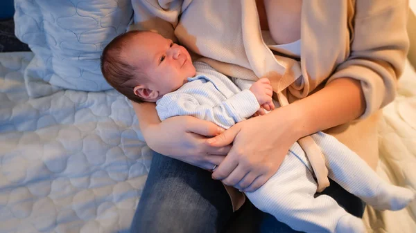 Bebé deitado nas mãos das mães à noite. Recém-nascido não consegue dormir e gritar. — Fotografia de Stock
