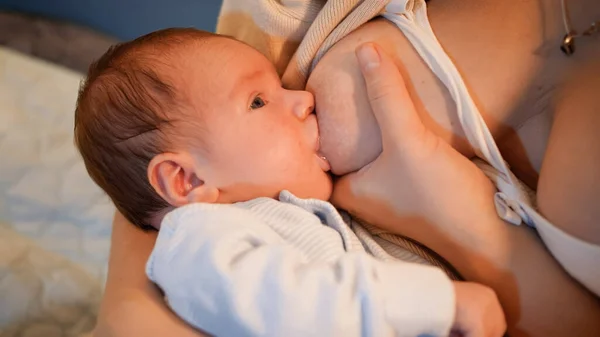 Porträt eines neugeborenen Jungen, der nachts vor dem Schlafengehen Milch aus der Brust saugt und isst. Konzept der gesunden und natürlichen Babynahrung. Gesundheit von Mutter und Kind — Stockfoto