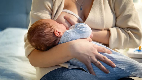 Primer plano del pequeño niño acostado en las manos de las madres y comiendo leche materna. Concepto de nutrición saludable y natural del bebé. Salud de la madre y del niño. — Foto de Stock