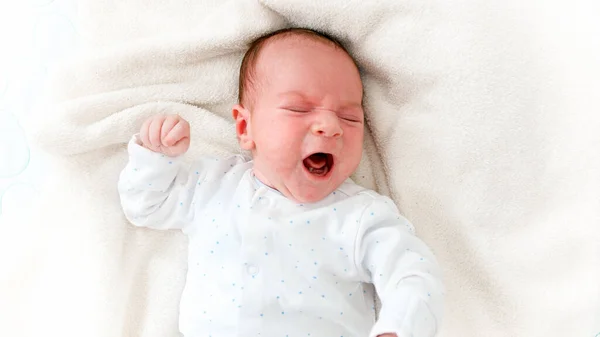 Retrato de primer plano del bebé recién nacido llorando acostado en una cuna — Foto de Stock