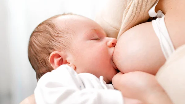 Nahaufnahme eines 2 Wochen alten Jungen, der Milch von der Brust seiner Mutter isst. Konzept der gesunden und natürlichen Babynahrung. — Stockfoto