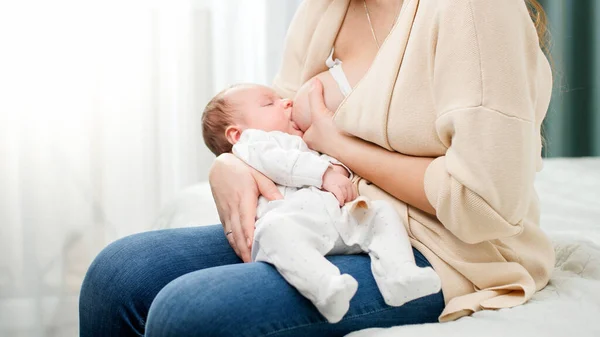 Słodki chłopczyk leżący na rękach matek i wysysający mleko z piersi. Pojęcie zdrowego i naturalnego żywienia piersią dla niemowląt. — Zdjęcie stockowe