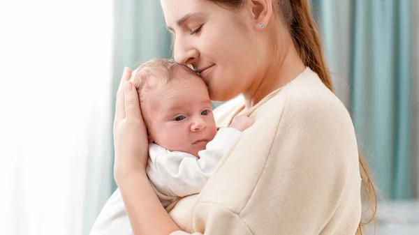 Portrait of newborn little baby on mothers hands against big window with bright sun. Concept of family happiness and loving parents with little children — Stock Photo, Image