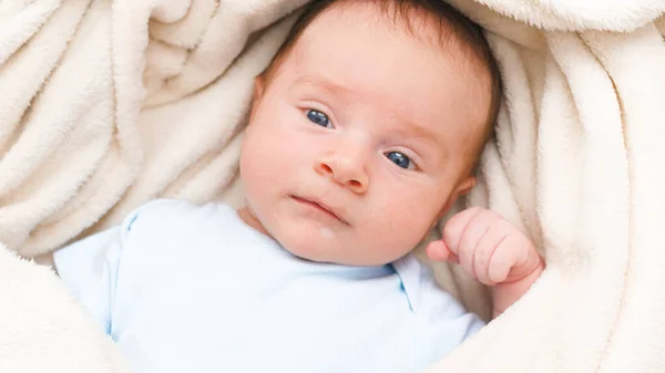 Retrato de vista superior de 1 mês de idade bebê pequeno com olhos azuis deitado no cobertor macio branco na cama e olhando na câmera. — Fotografia de Stock