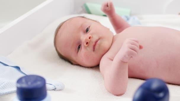 Porträt eines kleinen 1 Monate alten Jungen, der auf dem Wickeltisch im Schlafzimmer liegt. Konzept der Baby- und Neugeborenenhygiene und Gesundheitsfürsorge. Fürsorgliche Eltern mit kleinen Kindern. — Stockvideo