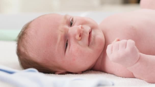 Retrato de primer plano de lindo bebé recién nacido acostado en el cambiador. Concepto de bebés e higiene y atención sanitaria del recién nacido. Cuidar a los padres con niños pequeños. — Vídeo de stock
