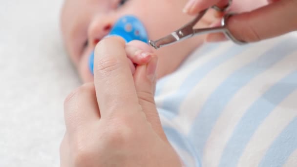 Nahaufnahme des Schneidens neugeborener Fingernägel mit einer speziellen Schere. Konzept der Baby- und Neugeborenenhygiene und Gesundheitsfürsorge. Fürsorgliche Eltern mit kleinen Kindern. — Stockvideo