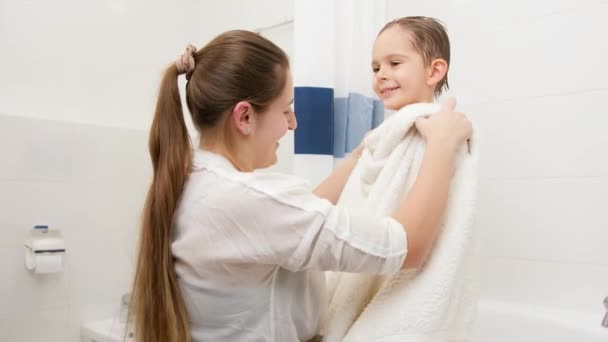 Jovem mãe carinhosa limpando e secando seu filho com toalha branca após a lavagem no banho. Conceito de higiene infantil e cuidados de saúde em casa. — Vídeo de Stock