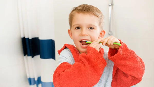 Retrato de niño lindo con cepillo de dientes limpiando los dientes por la mañana. Concepto de higiene dental infantil y atención sanitaria en el hogar. — Foto de Stock