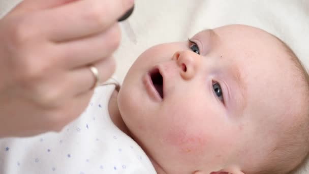 Closeup of little baby boy taking vitamin D from eyedropper. Concept of newborn healthcare and vaccination — Stock Video