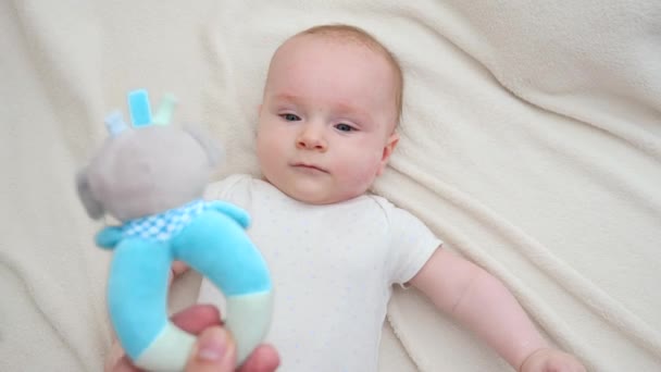 POV schot van de ouder vasthouden en schudden rammelaar speelgoed op haar baby liggend in wieg. Concept van onderwijs en ontwikkeling voor baby 's — Stockvideo