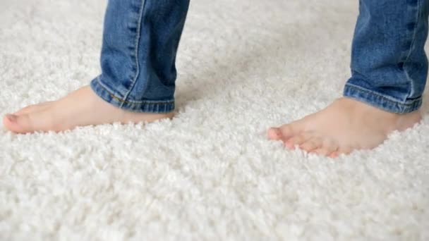 Gros plan de petits enfants nus pieds marchant sur tapis blanc doux — Video