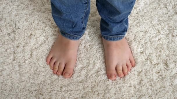 Cute little childs feet standing on soft white carpet and moving toes — Stock Video