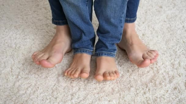 Zbliżenie żeńskich i dziecięcych stóp stojących na miękkim dywanie i ruchomych palcach — Wideo stockowe