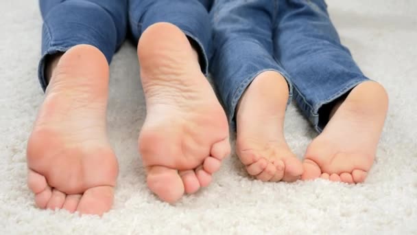 CLoseup родителей и ребенка, движущихся по полу дома и босых ног. Семья веселится и играет вместе — стоковое видео