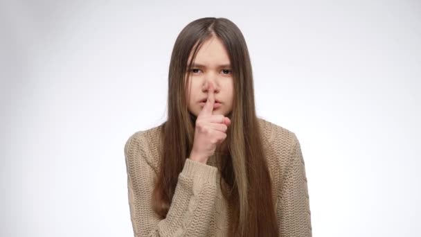 Studio portret van tiener meisje houdt vinger in de mond bij shhh gebaar. — Stockvideo