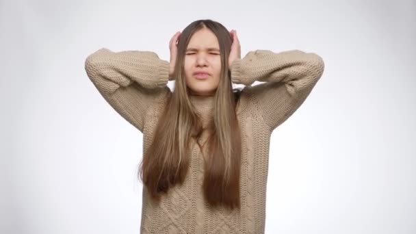 Jeune fille se sentant ennuyée par le bruit fort et souffrant de maux de tête fermer les oreilles avec les mains — Video