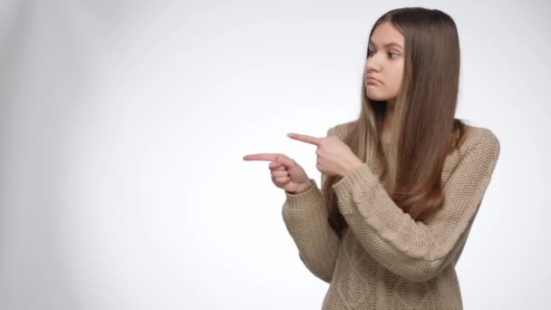 Young girl pointing on her side and showing invisible product. Place your product or object. Advertising template — Stock Video