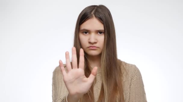 Berhenti atau tidak ada tanda-tanda. Gadis yang menunjukkan sikap menolak atau menyangkal dengan tangan di atas latar belakang studio putih — Stok Video