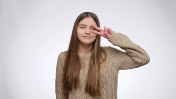 Счастливая улыбающаяся девушка-подросток танцует и празднует успех или победу на белом фоне студии — стоковое видео