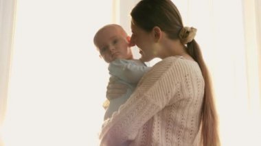 Gün batımında bebeğini öpmekten ve kucaklamaktan hoşlanan mutlu bir kadının portresi. Aile mutluluğu ve ebeveynlik kavramı