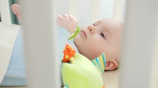 Beşikteki oyuncakla oynayan küçük bebeğe tırabzandan bak. Ebeveynlik kavramı, aile mutluluğu ve bebek gelişimi — Stok video