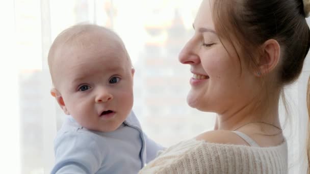 Aranyos kisfiú ölelgeti anyát és mosolyog a kamerában. A családi boldogság és a gyermekfejlődés fogalma — Stock videók