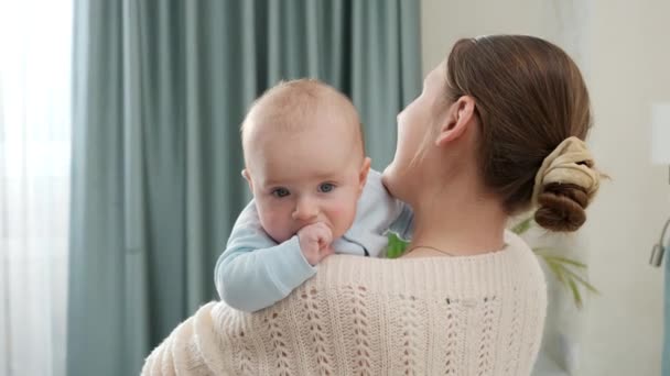 Mooie glimlachende vrouw streelde haar kleine zoontje in de slaapkamer. Begrip gezinsgeluk en ontwikkeling van kinderen — Stockvideo