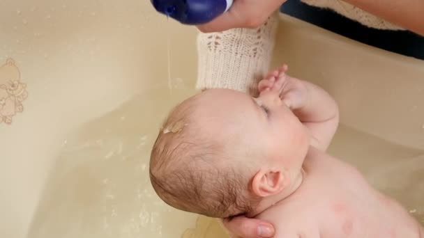 Matka nakłada szampon i myje głowę synkowi w wannie. Pojęcie rodzicielstwa, opieki nad dziećmi i opieki zdrowotnej. — Wideo stockowe
