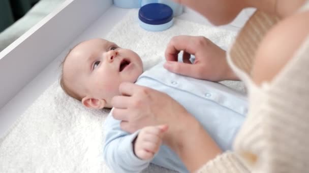 Glücklicher kleiner Junge lächelt, während Mutter kitzelt und mit ihm spielt. Konzept der Hygiene, Babypflege und Gesundheitsfürsorge — Stockvideo