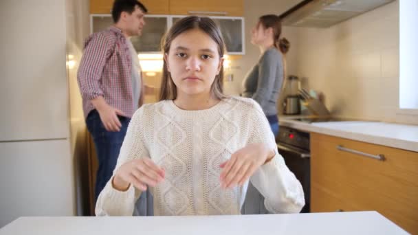 Zdenerwowana nastolatka zamykająca uszy rękami z powodu krzyków i kłótni rodziców w tle. Przemoc w rodzinie, konflikty i problemy w relacjach — Wideo stockowe