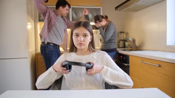 Tonårstjej sätter på hörlurar och njuter av musik medan föräldrar skriker ett gräl på bakgrunden. Familjevåld, konflikter och relationsproblem — Stockvideo
