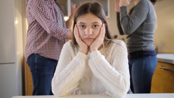 Retrato de una adolescente mirando a cámara e ignorando a los padres gritando y gritando durante el conflicto. Violencia familiar, conflictos y problemas de relación — Vídeo de stock
