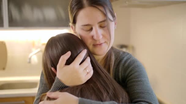 Retrato de la madre consolando y acariciando a su hija molesta llorando en la cocina. Padres que apoyan y reconfortan al niño — Vídeo de stock