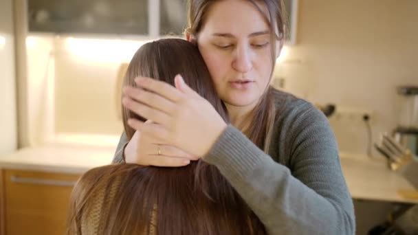 Junge Mutter küsst und umarmt weinende Tochter, nachdem sie über Probleme gesprochen hat. Eltern unterstützen und trösten Kind — Stockvideo