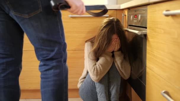 Padre enojado sosteniendo el cinturón de cuero y amenazas llorando hija sentada en el suelo. Concepto de violencia doméstica y agresión familiar. — Vídeo de stock