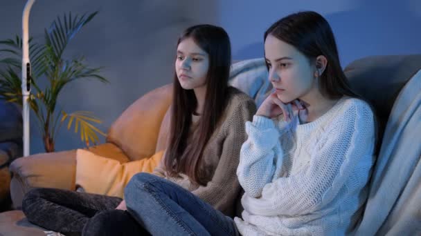 Two girls closing eyes and turning away while watching disgusting or miserable show on TV — Stock Video