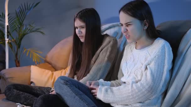 Young girls closing eyes and feeling disgusted while watching horror or scary show on TV — Stock Video