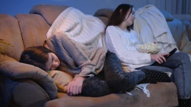 Genç arkadaşlar oturma odasında televizyon izlerken kanepede uyuyakaldılar.